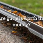 A pile of leaves and debris clogging a neglected gutter, causing water to overflow and damage the surrounding area